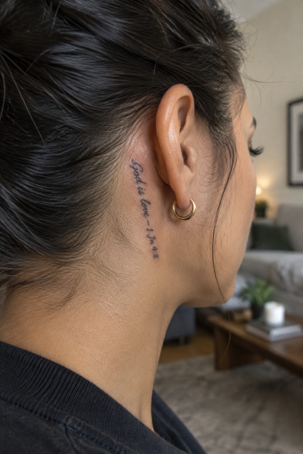 Close-up side view of a small cursive scripture tattoo reading 