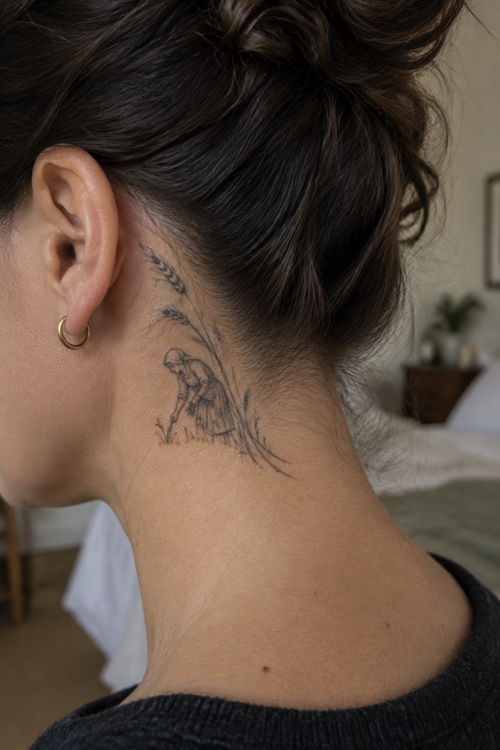 Woman's neck with black ink tattoo of woman harvesting wheat stalks